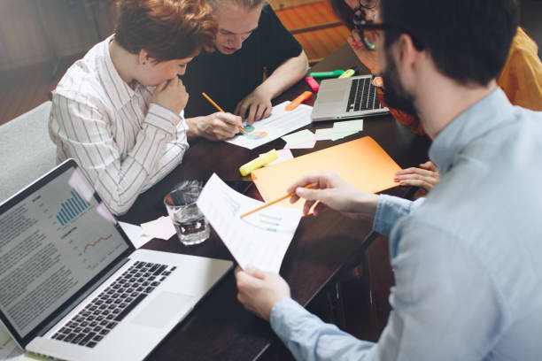 istock Group of marketers is thinking of a new development plan. Young entrepreneurs discuss schedules and diagrams 683236626