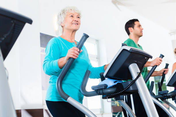 istock Senior woman on elliptical trainer exercising in gym 683237018