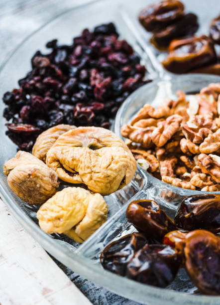 istock Assorted dried fruits and nuts on a glass plate.Dates, figs, raisins, dried apricots, walnuts 683240102