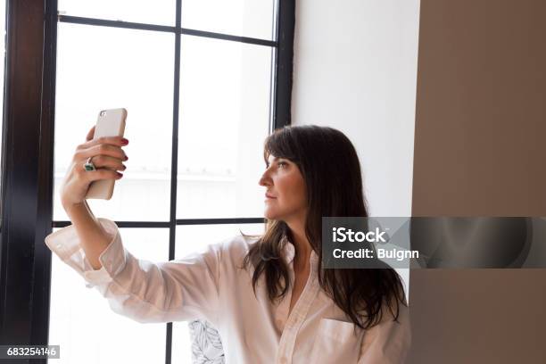 Beautiful Business Woman Taking A Selfie By The Window Stock Photo - Download Image Now