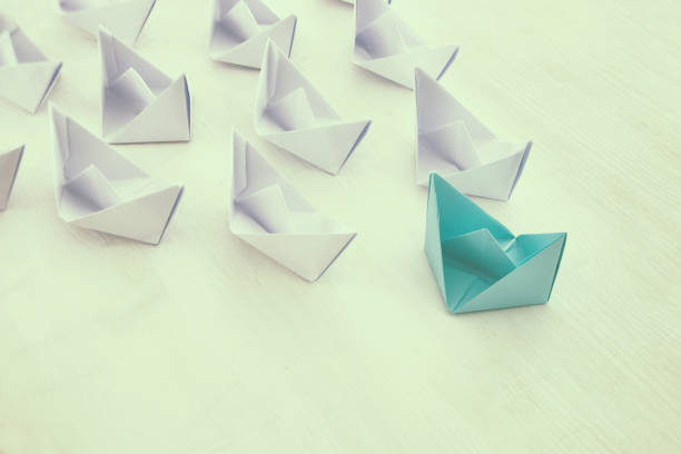 istock leadership concept, paper boat leading followers 683257694