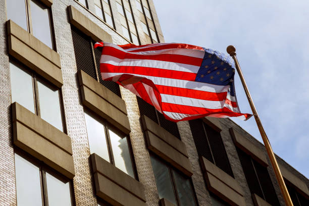 istock American flag waving against two skyscrapers and a blue sky. 683260592