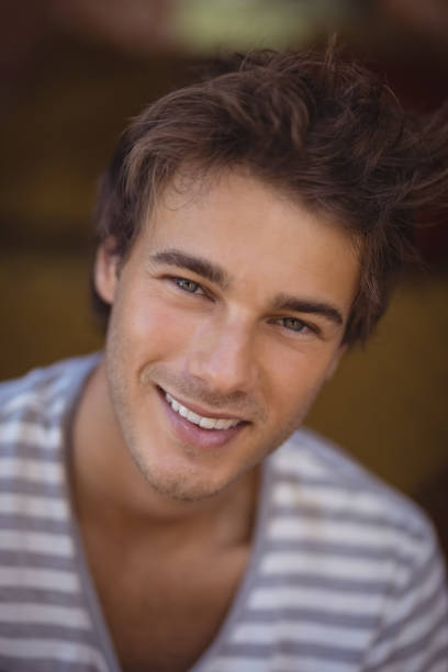 Close up portrait of handsome afro american guy looking at camera and smiling