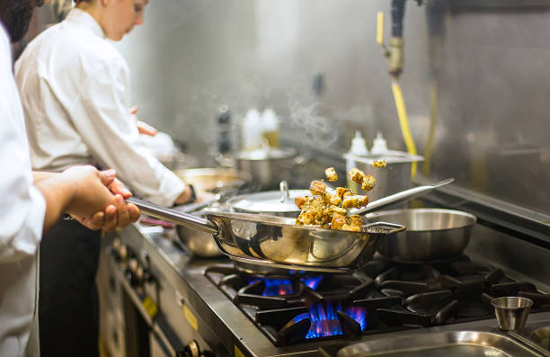 chef prepara cocina en cocina de hotel - alimento tostado fotos fotografías e imágenes de stock