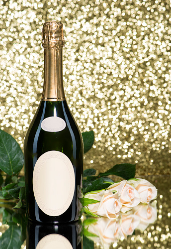 Romatic bouquet of white roses and a bottle of champagne