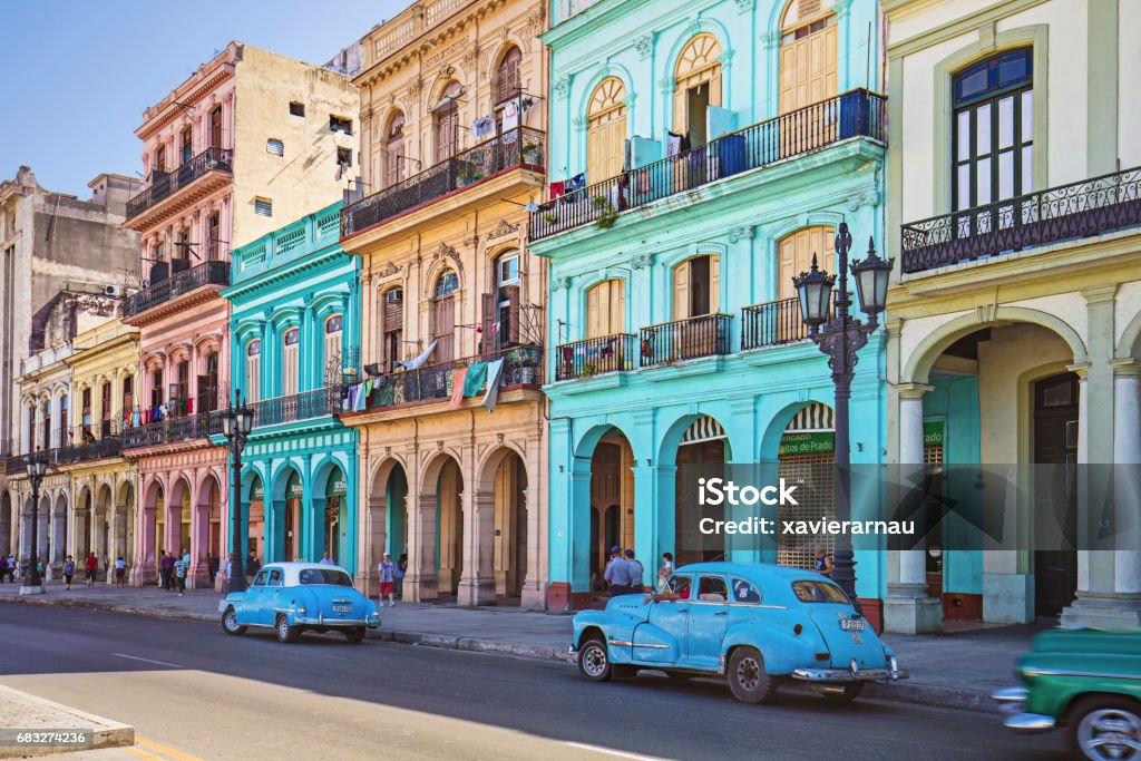 Vintage taxis on street against historic buildings Vintage cars parked on roadside. Taxis on street in city. Vehicles against residential buildings. Cuba Stock Photo