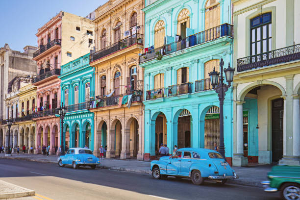 Vintage taxis on street against historic buildings Vintage cars parked on roadside. Taxis on street in city. Vehicles against residential buildings. havana photos stock pictures, royalty-free photos & images