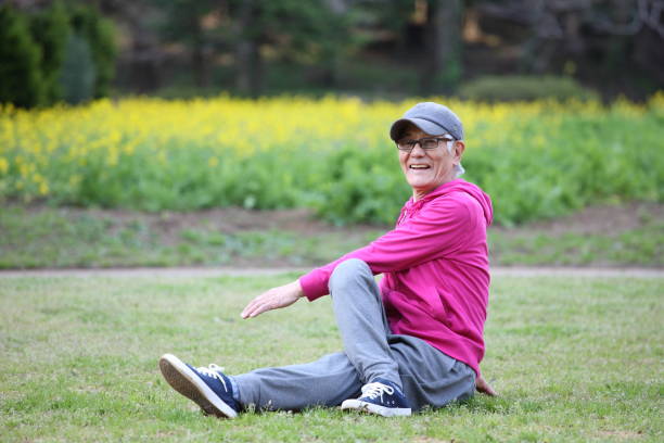 istock senior Japanese man doing seated torso twist stretch on a lawn 683277728