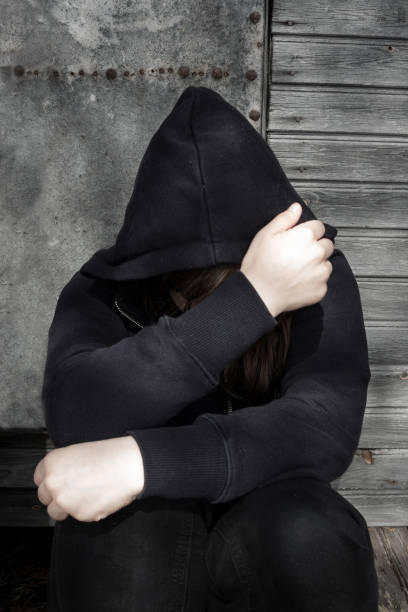 istock Depressed person sitting against wall and covers her face with her hands 683290476