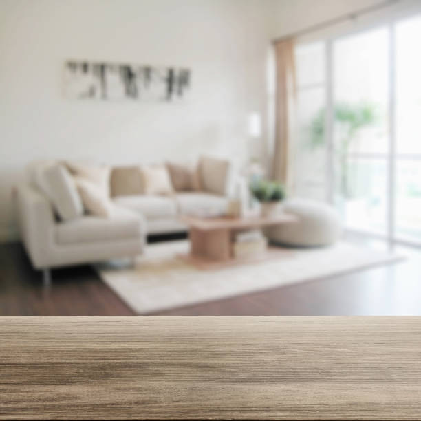 wooden table top with blur of modern living room interior stock photo