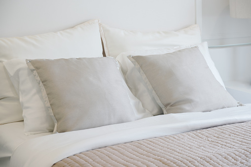 Light gray pillow setting on bed in nice vibe bedroom modern interior style