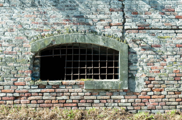 Old fortress dungeon window with metal gratings.