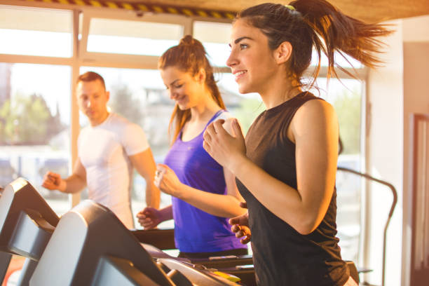istock Young woman running on treadmill in gym. 683307452