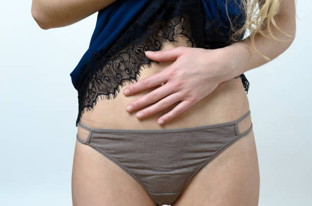 Woman in nightie holding her stomach