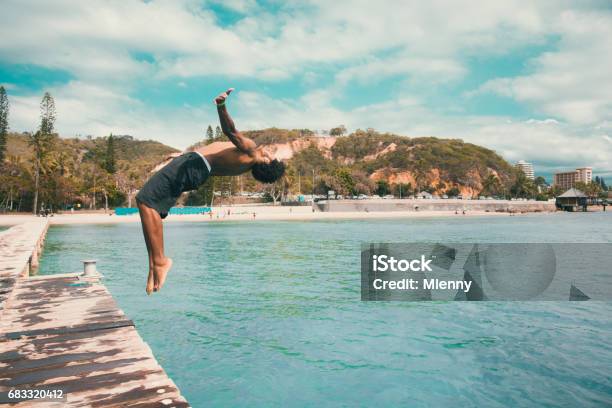 Backflip Pacific Islander Jumping Into The Water Noumea Beach New Caledonia Stock Photo - Download Image Now