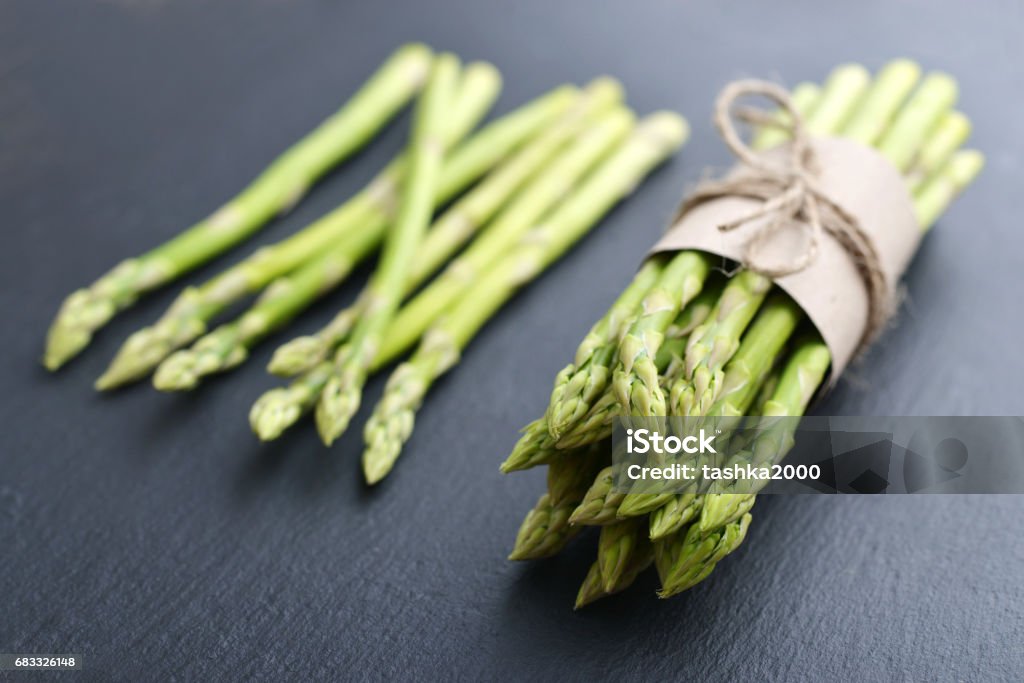 Bunch of asparagus Bunch of asparagus over black slate background closeup Asparagus Stock Photo