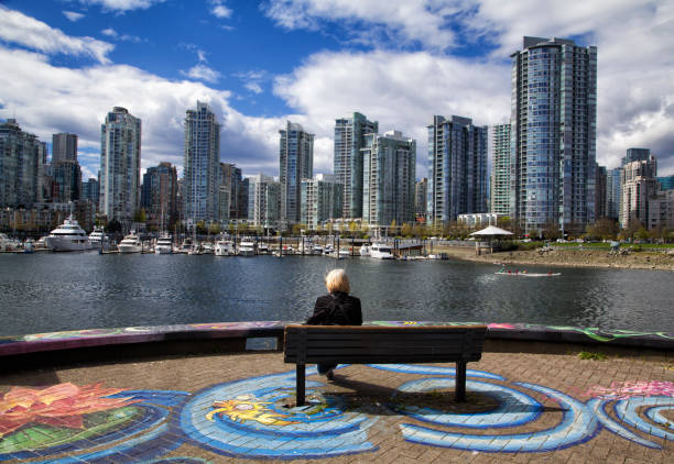 mujer disfrutando de la vista en false creek, vancouver, canadá - bench mountain park sitting fotografías e imágenes de stock