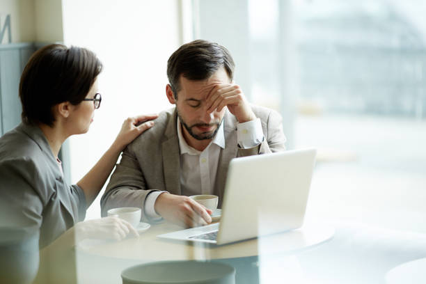 Business trouble Businesswoman comforting frustrated or tired co-worker melancholy computer support specialist stock pictures, royalty-free photos & images