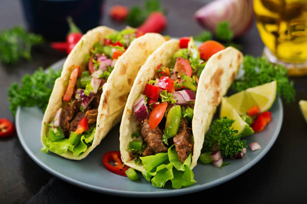 istock Mexican tacos with beef in tomato sauce and salsa 683340326