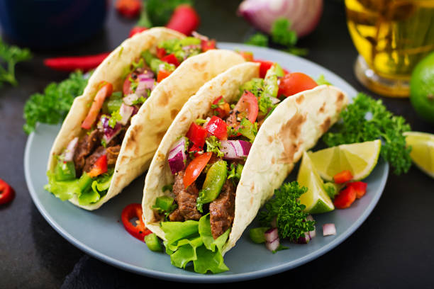 istock Mexican tacos with beef in tomato sauce and salsa 683340338