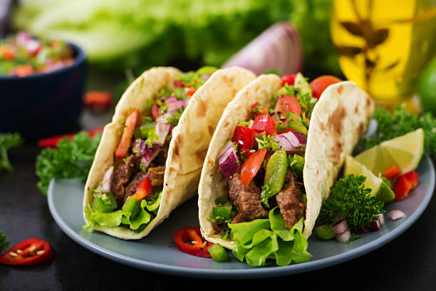 istock Mexican tacos with beef in tomato sauce and salsa 683340342