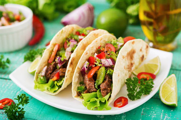 istock Mexican tacos with beef in tomato sauce and salsa 683340364