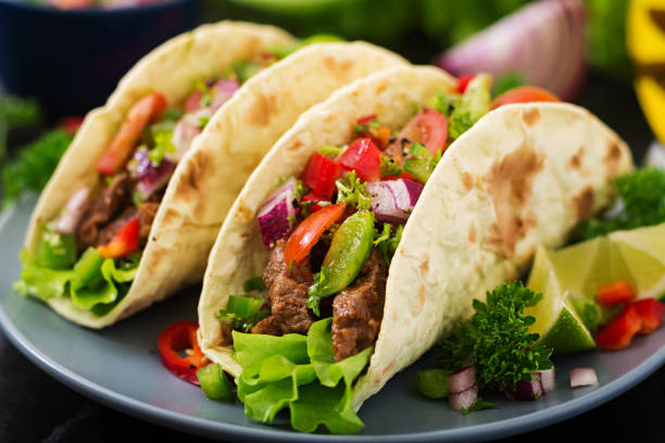 istock Mexican tacos with beef in tomato sauce and salsa 683340366