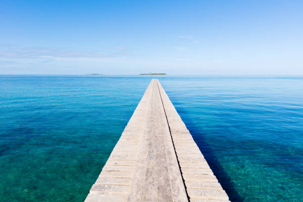 Endless Jetty to the Horizon Noumea New Caledonia Endless wooden jetty over clean turquoise water to the horizon under blue clear summer sky. Noumea Beach, Noumea, New Caledonia, South West Pacific Ocean new caledonia photos stock pictures, royalty-free photos & images