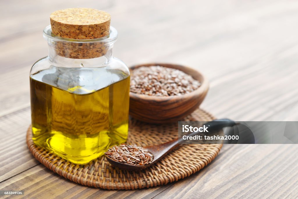 Flax seeds and oil Flax seeds and oil in bottle on wooden background Flax Seed Stock Photo