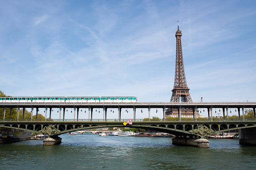 Train travels on Pont de Bir Hakeim in front of Eiffel tower
