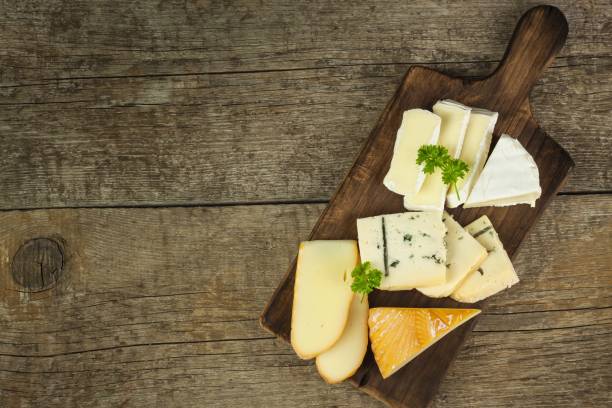 istock Different types of cheese on a wooden cutting board. 683352524