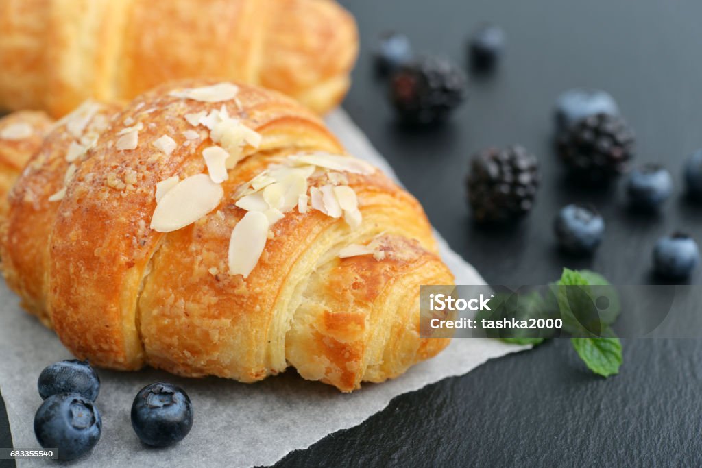 Croissant with fresh berries Croissant with fresh berries on black slate background Continental Breakfast Stock Photo