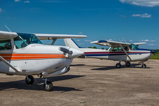 Two private light planes parked on the airfield in summer