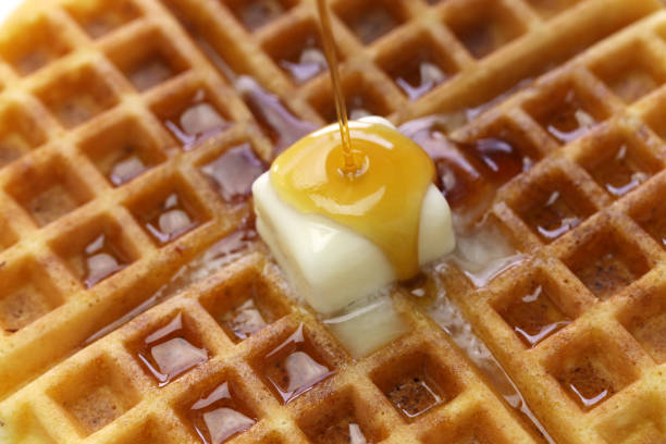 gießen ahornsirup über hausgemachte amerikanische runde waffeln mit butter - waffle syrup pouring breakfast stock-fotos und bilder