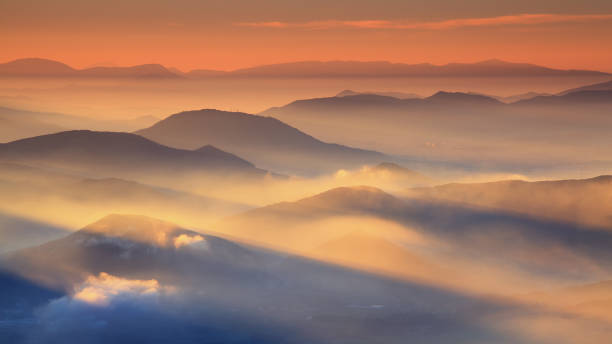 Beautiful sunrise over cloudy mountains stock photo