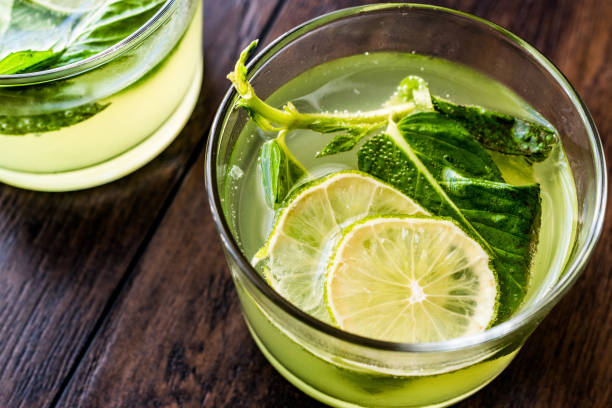 Refreshing green bitter lemon cocktail with mint leaves and lime. Refreshing green bitter lemon cocktail with mint leaves and lime. Beverage Concept. lime basil plant stock pictures, royalty-free photos & images