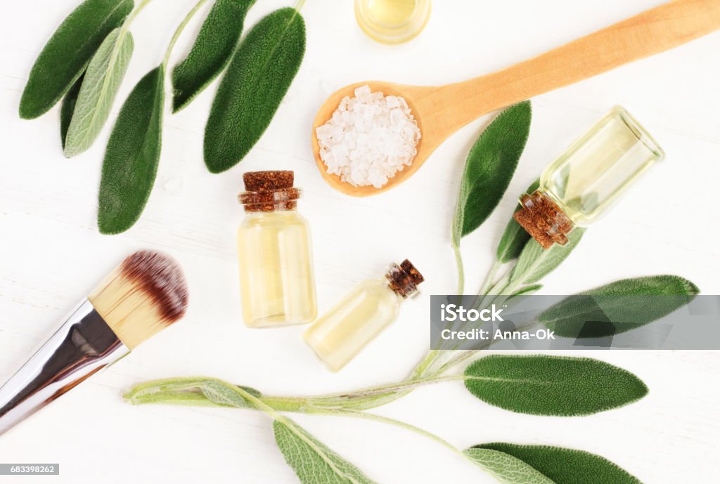 Aceite esencial salvia (Salvia officinalis) hojas y botellas de aceite de aroma. - Foto de stock de Vista desde arriba libre de derechos