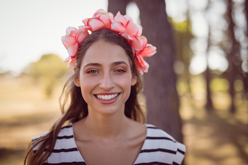 Close up portrait of smiling beautiful woman wearing flowers