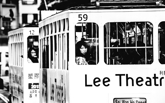 Hong Kong, Hong Kong S.A.R. - May 5, 2014: People looking out from old double deck street car window in Causeway Bay.