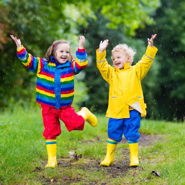 istock Kids play in rain and puddle in autumn 683411118
