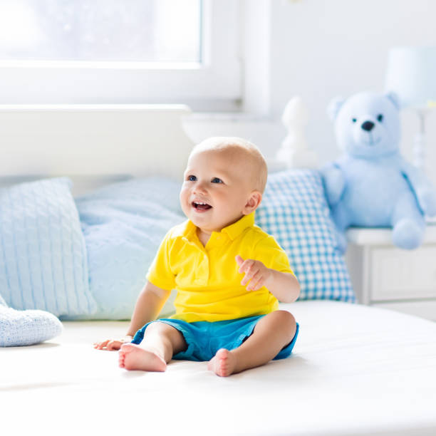 istock Baby boy playing on bed in sunny nursery 683412652