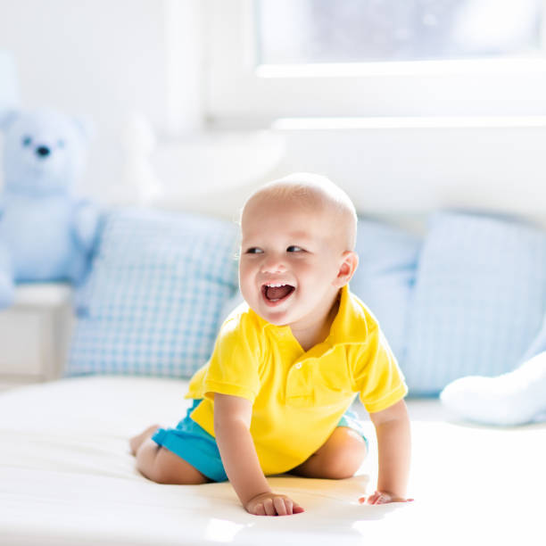 istock Baby boy playing on bed in sunny nursery 683412676