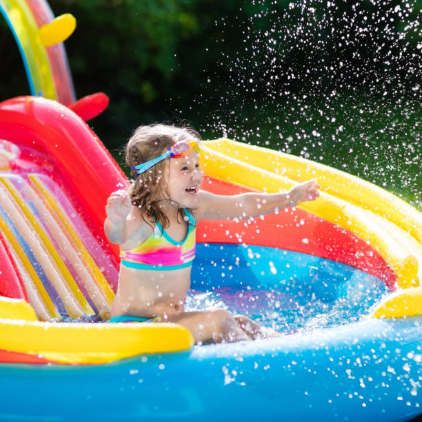 istock Child in garden swimming pool with slide 683417632
