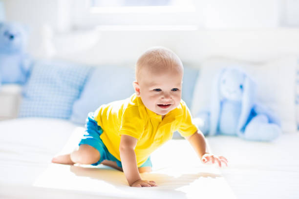 istock Baby boy playing on bed in sunny nursery 683417686