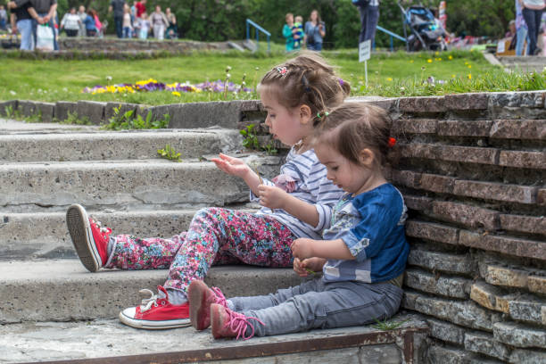 istock two little girls sitting on the steps 683418498