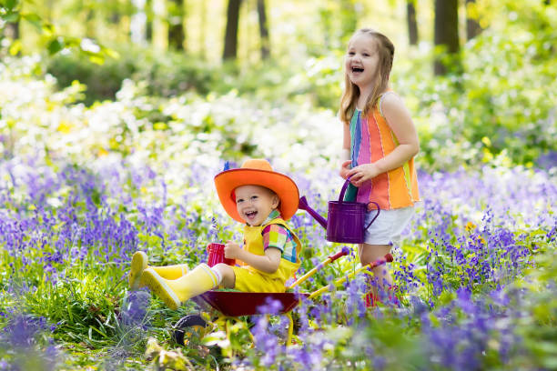 istock Kids with bluebell flowers, garden tools 683418742