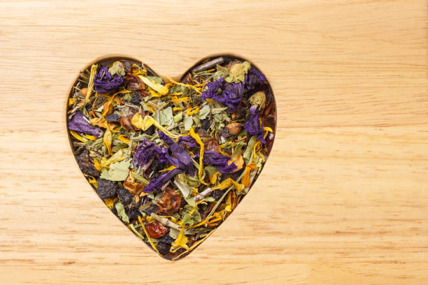 istock Dried herb leaves heart shaped on wooden surface 683421320