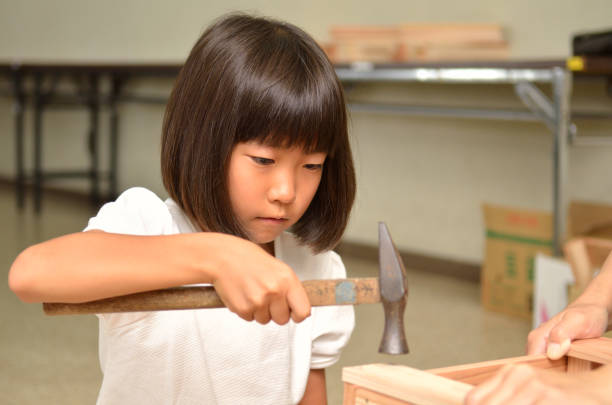 Grandfather with his grandchildren in the workshop making wooden frames