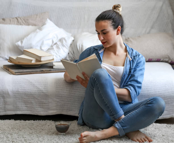 istock girl reading a book in a cozy room 683424872