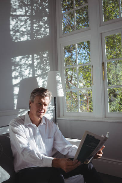 istock Portrait of happy man reading magazine 683430892